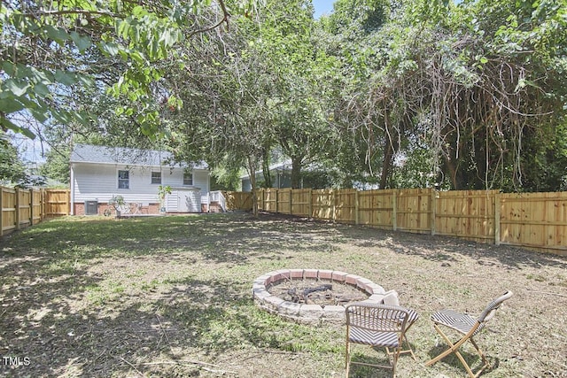 fenced backyard featuring a fire pit and cooling unit