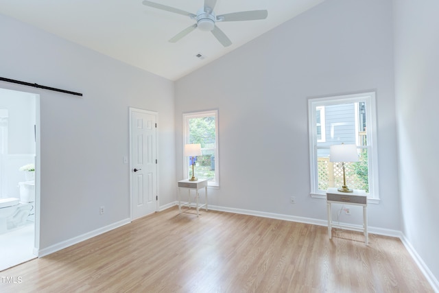 2222 Pathway Dr, Chapel Hill, NC 27516 - spare room featuring light wood-style flooring, a barn door, ceiling fan, and high vaulted ceiling