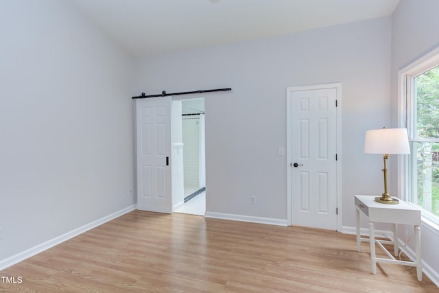 2222 Pathway Dr, Chapel Hill, NC 27516 - bedroom with light wood-style floors and a barn door