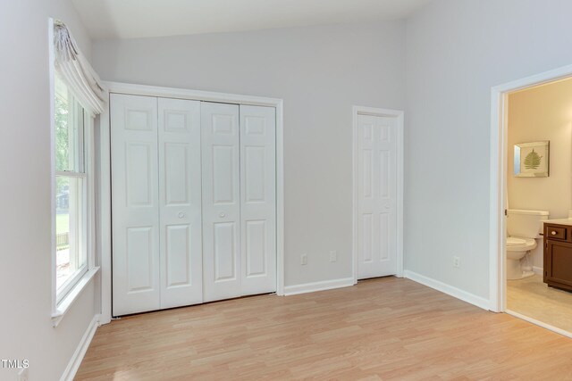 2222 Pathway Dr, Chapel Hill, NC 27516 - unfurnished bedroom with light wood-style floors, lofted ceiling, ensuite bathroom, and two closets