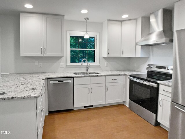 1104 Theresa Ct, Raleigh, NC 27615 - kitchen with stainless steel appliances, wall chimney exhaust hood, a sink, white cabinetry, and light stone countertops