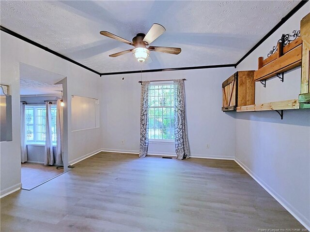 6261 Stoney Point Loop, Fayetteville, NC 28306 - unfurnished room with a ceiling fan, a textured ceiling, wood finished floors, baseboards, and crown molding