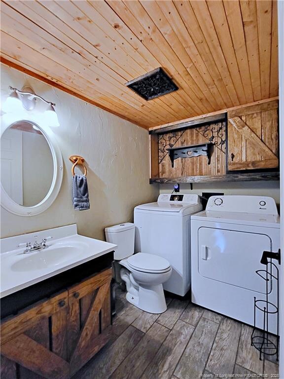 6261 Stoney Point Loop, Fayetteville, NC 28306 - bathroom featuring wood ceiling, washer and clothes dryer, toilet, wood finished floors, and vanity