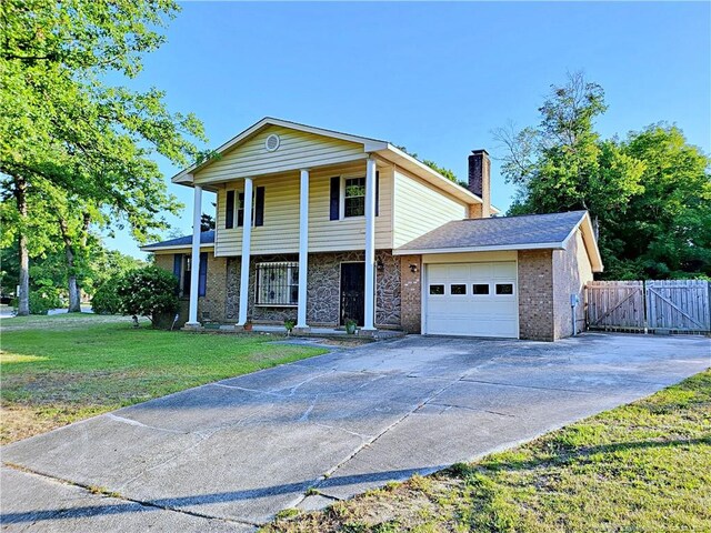 6261 Stoney Point Loop, Fayetteville, NC 28306 - view of front of property with a garage, a gate, a chimney, concrete driveway, and covered porch