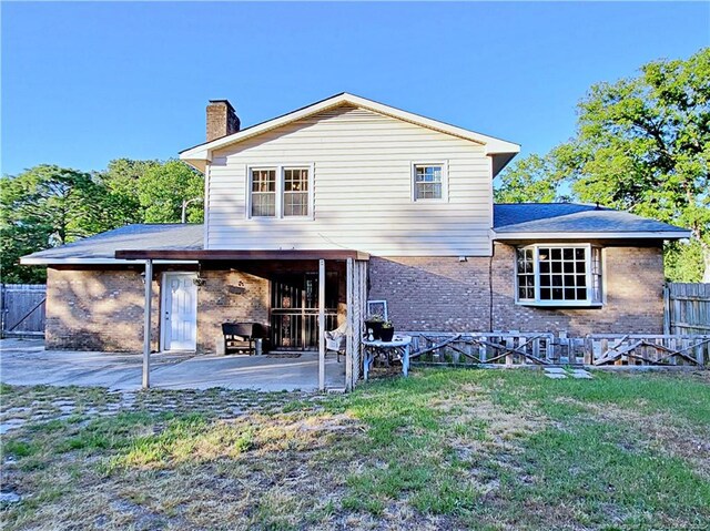 6261 Stoney Point Loop, Fayetteville, NC 28306 - rear view of property with brick siding, a chimney, and a patio area
