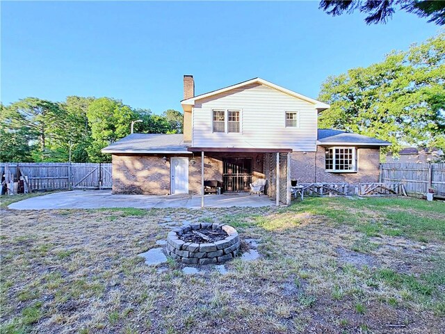 6261 Stoney Point Loop, Fayetteville, NC 28306 - back of house with a fire pit, a patio area, a chimney, and brick siding