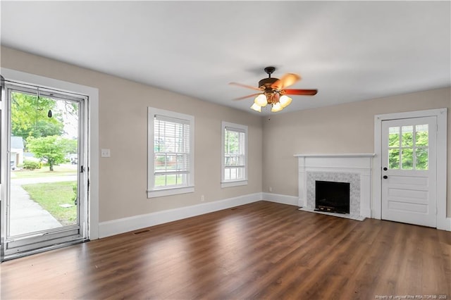 1001 N Orange Ave, Dunn, NC 28334 - unfurnished living room with baseboards, dark wood-style flooring, a ceiling fan, and a high end fireplace