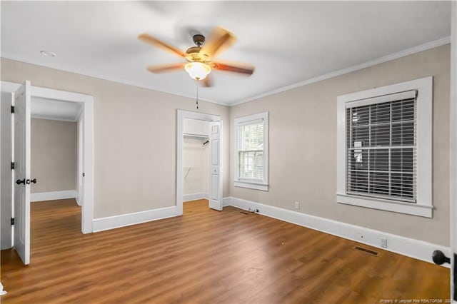 1001 N Orange Ave, Dunn, NC 28334 - unfurnished bedroom featuring baseboards, wood finished floors, ornamental molding, a closet, and ceiling fan
