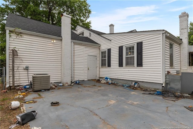 1001 N Orange Ave, Dunn, NC 28334 - rear view of property featuring a patio area, a chimney, central AC, and a shingled roof