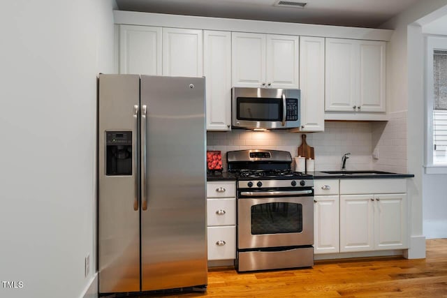 253 Tobacco Farm Way, Chapel Hill, NC 27516 - kitchen featuring appliances with stainless steel finishes, a sink, dark countertops, and white cabinets