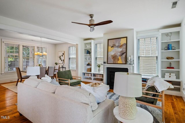 253 Tobacco Farm Way, Chapel Hill, NC 27516 - living area with wood finished floors, a chandelier, a ceiling fan, a fireplace, and plenty of natural light
