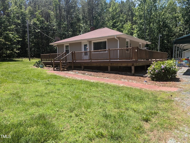 rear view of property with a deck, a lawn, and a wooded view
