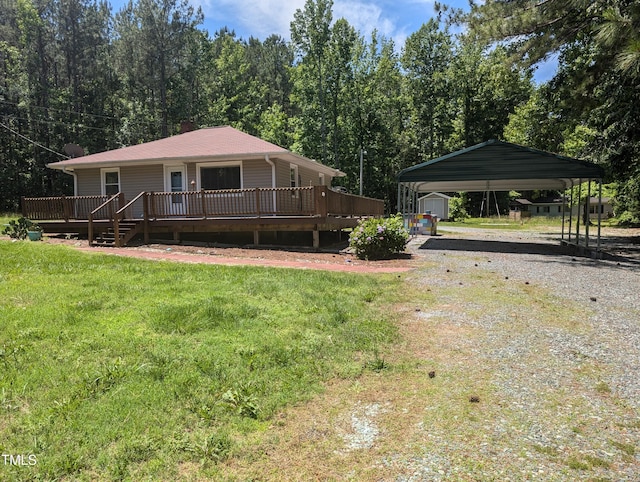 view of front facade featuring gravel driveway, a wooden deck, a front lawn, and a carport