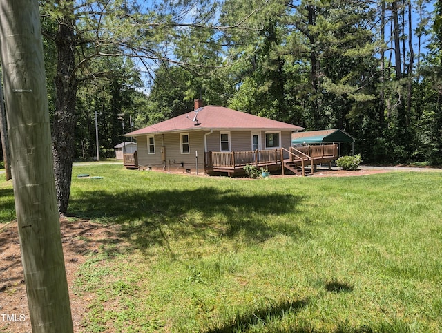 back of house featuring a deck and a lawn
