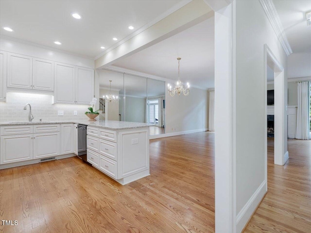 3347 Ridgecrest Ct, Raleigh, NC 27607 - kitchen featuring ornamental molding, a sink, a chandelier, a peninsula, and light wood-style floors
