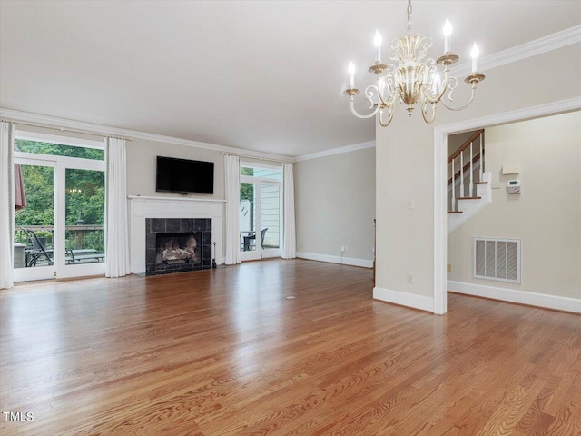 3347 Ridgecrest Ct, Raleigh, NC 27607 - unfurnished living room featuring crown molding, a chandelier, baseboards, light wood finished floors, and stairs