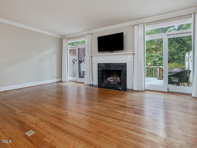 3347 Ridgecrest Ct, Raleigh, NC 27607 - unfurnished living room featuring ornamental molding, light wood-type flooring, a tiled fireplace, and baseboards