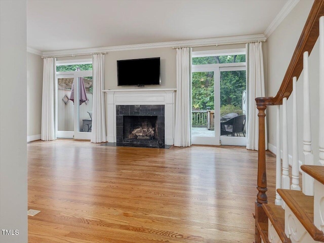 3347 Ridgecrest Ct, Raleigh, NC 27607 - unfurnished living room featuring ornamental molding, stairway, light wood finished floors, a fireplace, and baseboards