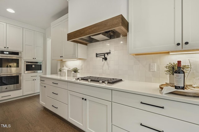 1141 Duke Farm Dr, Wake Forest, NC 27587 - kitchen featuring stainless steel appliances, custom exhaust hood, light countertops, and white cabinetry