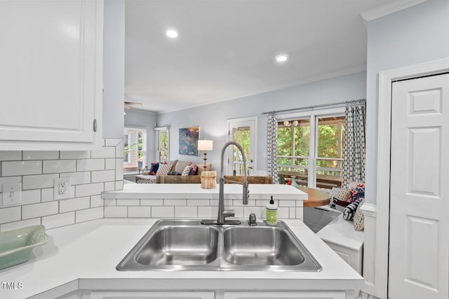 19 Knightsbridge Ct, Durham, NC 27707 - kitchen with a sink, light countertops, crown molding, open floor plan, and white cabinetry