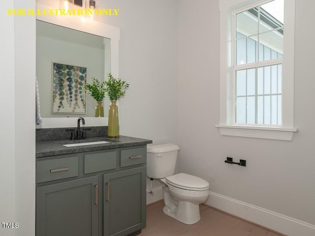 bathroom featuring baseboards, toilet, vanity, and wood finished floors