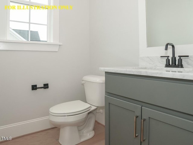 bathroom with toilet, vanity, wood finished floors, and baseboards