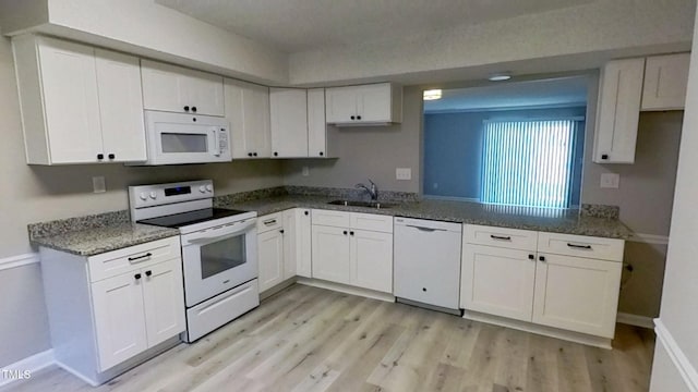 1227 Seaton Rd Unit 60, Durham, NC 27713 - kitchen featuring white appliances, a sink, light wood-type flooring, white cabinetry, and baseboards