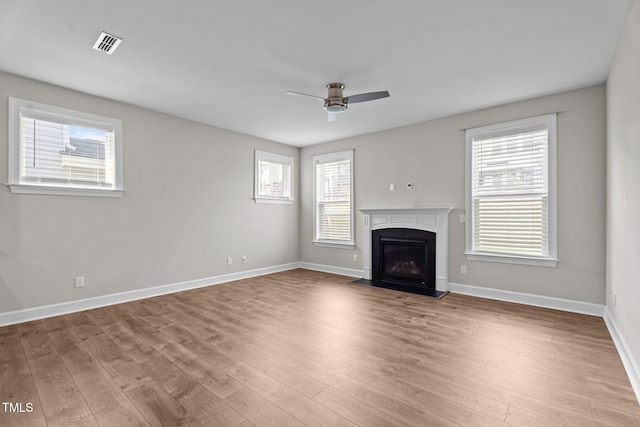 6624 Vestal St, Wake Forest, NC 27587 - unfurnished living room with wood finished floors, ceiling fan, a fireplace with flush hearth, and healthy amount of natural light