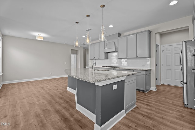 6624 Vestal St, Wake Forest, NC 27587 - kitchen with a sink, gray cabinetry, backsplash, wood finished floors, and premium range hood
