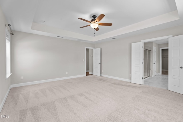 6624 Vestal St, Wake Forest, NC 27587 - unfurnished bedroom featuring a tray ceiling, light carpet, baseboards, and a ceiling fan
