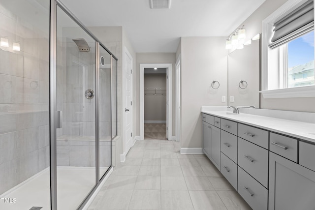6624 Vestal St, Wake Forest, NC 27587 - full bath with double vanity, a stall shower, a walk in closet, baseboards, and tile patterned flooring