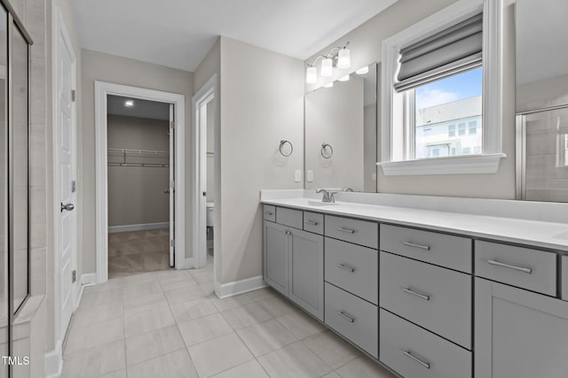 6624 Vestal St, Wake Forest, NC 27587 - full bathroom with double vanity, a stall shower, a spacious closet, toilet, and baseboards