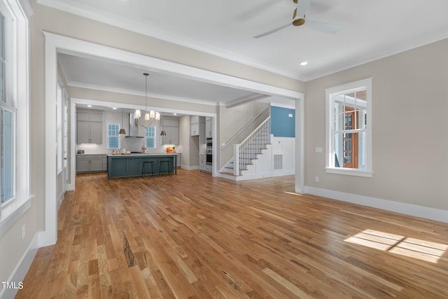 1029 Whitehall Cir, Durham, NC 27713 - unfurnished living room with a chandelier, light wood-style flooring, ceiling fan, ornamental molding, and plenty of natural light