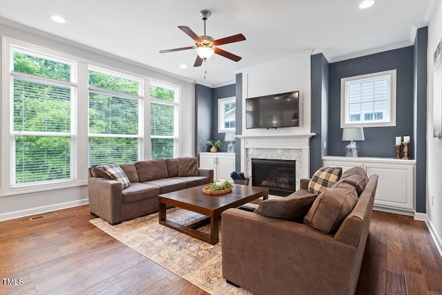 213 Preatonwood Dr, Apex, NC 27539 - living room featuring a ceiling fan, ornamental molding, a high end fireplace, dark wood-style flooring, and baseboards
