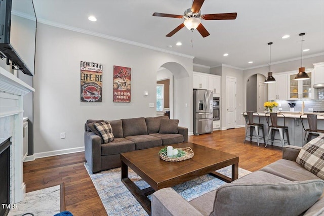 213 Preatonwood Dr, Apex, NC 27539 - living area featuring arched walkways, recessed lighting, a ceiling fan, a premium fireplace, and wood finished floors