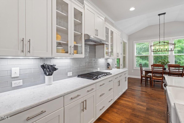 213 Preatonwood Dr, Apex, NC 27539 - kitchen featuring stainless steel gas stovetop, under cabinet range hood, vaulted ceiling, white cabinets, and dark wood finished floors