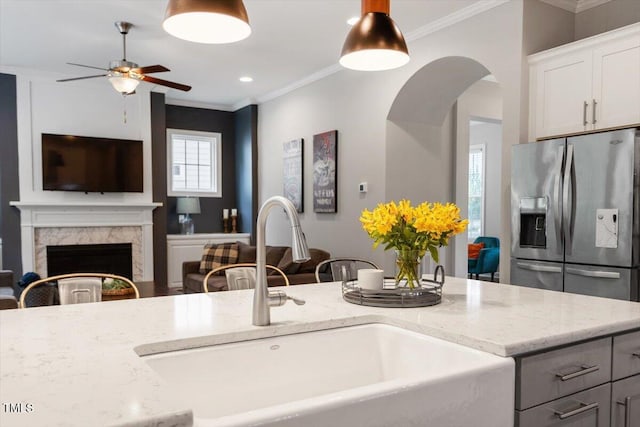 213 Preatonwood Dr, Apex, NC 27539 - kitchen featuring a sink, stainless steel refrigerator with ice dispenser, ceiling fan, light stone countertops, and crown molding