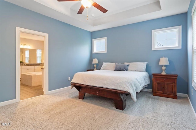 213 Preatonwood Dr, Apex, NC 27539 - carpeted bedroom featuring a tray ceiling, ensuite bathroom, baseboards, and a ceiling fan