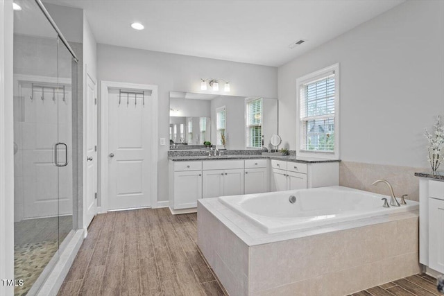 213 Preatonwood Dr, Apex, NC 27539 - full bathroom with a bath, a shower stall, wood finished floors, vanity, and recessed lighting