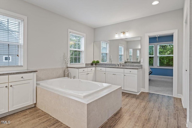 213 Preatonwood Dr, Apex, NC 27539 - full bath with a garden tub, wood finished floors, vanity, and healthy amount of natural light
