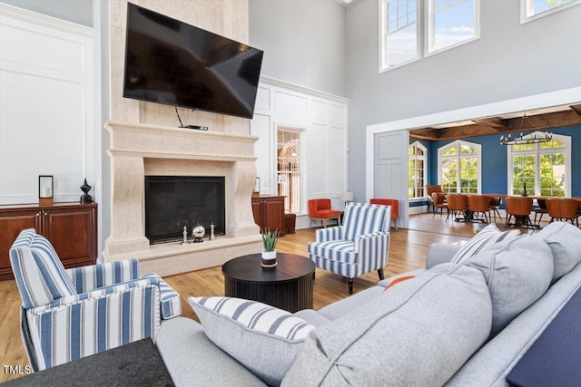 213 Preatonwood Dr, Apex, NC 27539 - living room featuring a towering ceiling, wood finished floors, a fireplace, and a chandelier