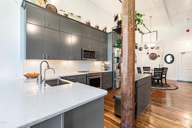 1535 Caraleigh Mills Ct Unit 111, Raleigh, NC 27603 - kitchen featuring appliances with stainless steel finishes, a sink, hardwood / wood-style floors, decorative backsplash, and beam ceiling
