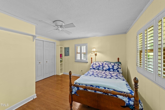 205 W Oak Ave, Wake Forest, NC 27587 - bedroom with electric panel, wood finished floors, baseboards, a textured ceiling, and ceiling fan
