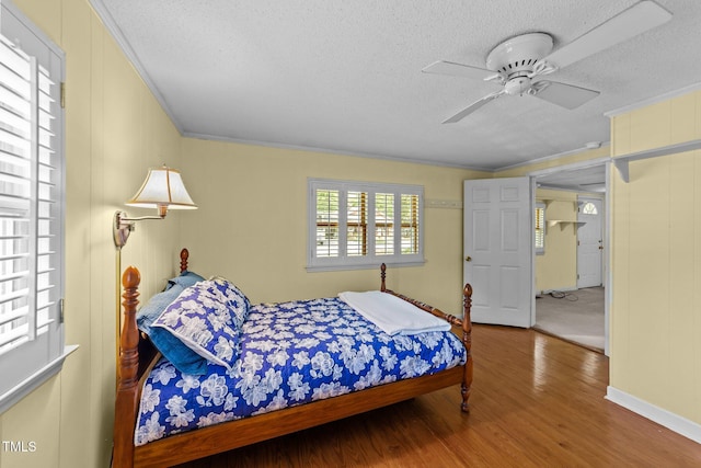 205 W Oak Ave, Wake Forest, NC 27587 - bedroom featuring a textured ceiling, wood finished floors, ornamental molding, and ceiling fan