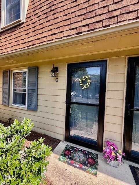 141 Jones Franklin Rd Unit G, Raleigh, NC 27606 - doorway to property featuring roof with shingles and a porch