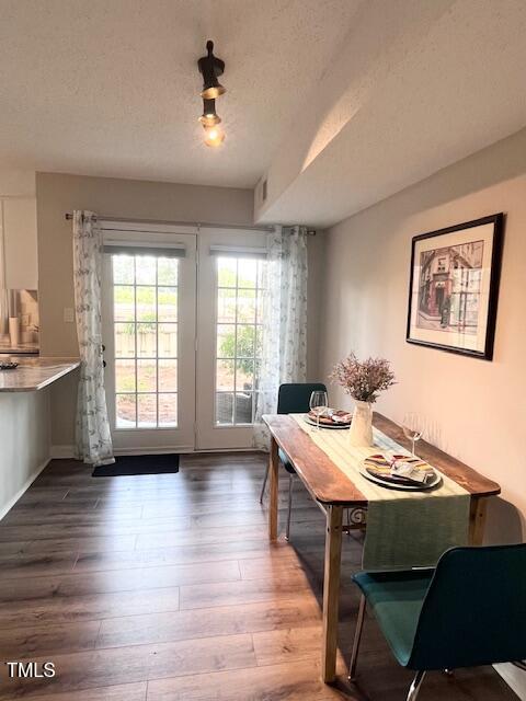 141 Jones Franklin Rd Unit G, Raleigh, NC 27606 - dining area with wood finished floors and a textured ceiling