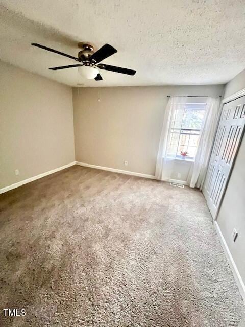 141 Jones Franklin Rd Unit G, Raleigh, NC 27606 - unfurnished bedroom with a textured ceiling, baseboards, carpet floors, a closet, and ceiling fan