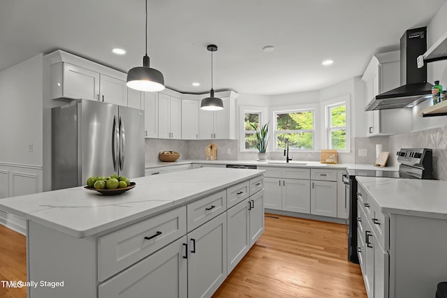 4259 Old Faison Rd, Knightdale, NC 27545 - kitchen featuring stainless steel appliances, wall chimney exhaust hood, a sink, a center island, and white cabinets