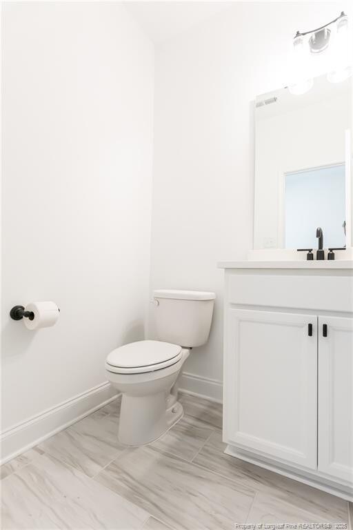 00 John B Carter Rd, Fayetteville, NC 28312 - bathroom featuring toilet, baseboards, and vanity