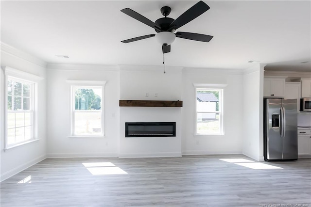 00 John B Carter Rd, Fayetteville, NC 28312 - unfurnished living room with plenty of natural light, a glass covered fireplace, light wood-style floors, a ceiling fan, and crown molding